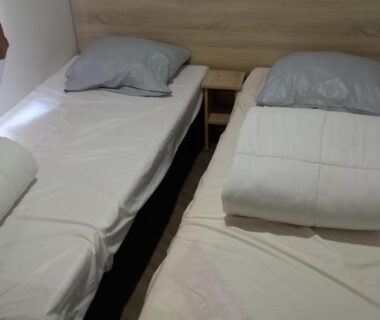 Chambre avec deux lits simples et table de chevet dans le MH 502 Bois Dormant annexe