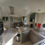 Cuisine ouverte et séjour dans le mobil home MH 515 AMIRA TOUT CONFORT
