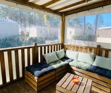 Terrasse couverte avec banquette et table en bois du MH 542 Spacieux 40m2 Camping 4 étoiles