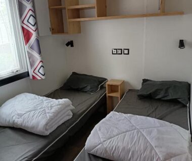 Chambre avec deux lits simples étagères et fenêtre dans le MH F101 Camping Bois Masson