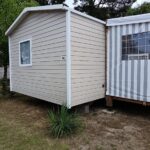 Extérieur de mobil-home beige adjacent à un autre au MH F101 du Camping Bois Masson