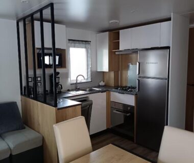 Intérieur du mobil-home avec cuisine et coin repas du MH F101 Camping Bois Masson