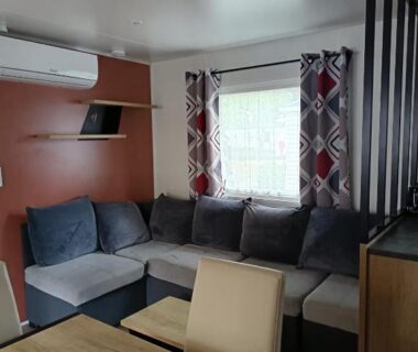 Coin salon avec banquette et table dans le MH F101 Camping Bois Masson