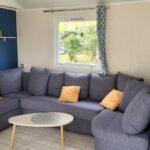 Salon avec canapé d'angle et table basse dans le mobilhome MH GRAND CONFORT 40 m2 3CH 2 SDB 2 TOILETTES