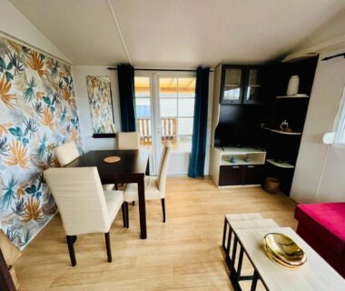 Intérieur salon avec table chaises et canapé du MH J08 au Camping Siblu La plage