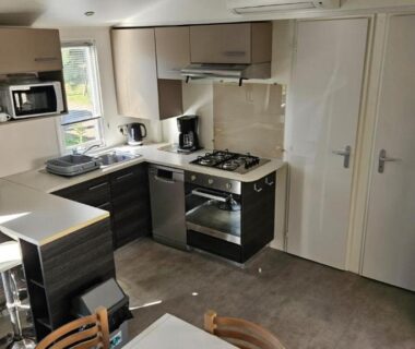 Cuisine équipée et coin repas dans le MH T14 entre pins et océan 2 chambres 2 salles de bain
