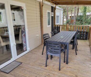 Terrasse en bois avec table et chaises du MH h007 3chambres et 1 sale de bain dans camping 4 étoiles