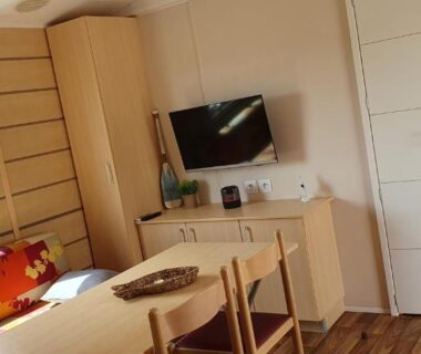 Intérieur salon avec canapé et télévision dans le mobil home MH135 camping NOVELA