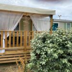 Terrasse couverte du mobil home avec voilages au MH148 camping NOVELA