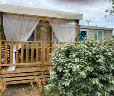 Terrasse couverte du mobil home avec voilages au MH148 camping NOVELA