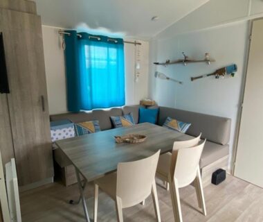 Coin repas et salon avec table et banquette dans le mobil home MH148 camping NOVELA