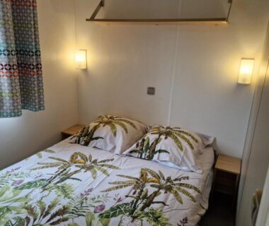 Chambre avec lit double, tables de chevet et lampes murales dans le MH2-CONFORT 3CH