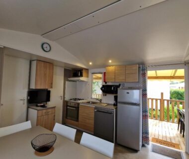 Cuisine ouverte avec table et terrasse visible du MH2-CONFORT 3CH