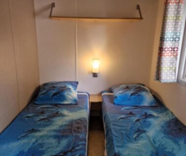 Chambre avec deux lits simples et lampe murale dans le MH2-CONFORT 3CH