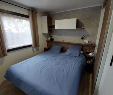 Chambre avec lit double et fenêtre dans le mobil-home MH263 3 chambres et 2 salles de bain