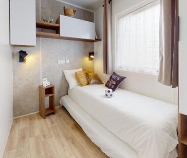 Chambre avec lit rangements et fenêtre dans MH263 3 chambres et 2 salles de bain dans camping 4 étoiles