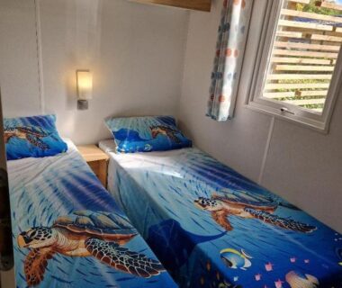 Intérieur chambre avec deux lits et parures tortue dans le MH3-Confort Plus