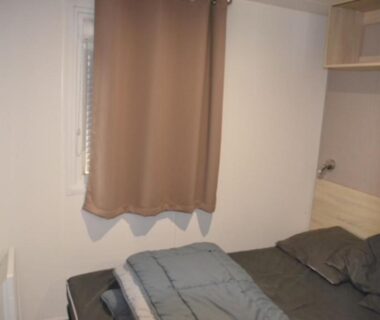 Chambre avec lit double et rideau dans MHT20 3 chambres et 2 sdb dans camping 4 étoiles