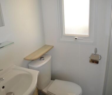 Salle de bain avec lavabo toilettes et fenêtre dans le MHT20 3 chambres et 2 sdb dans camping 4 étoiles