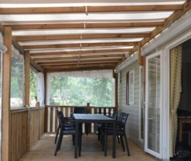 Terrasse couverte avec table et chaises du MHT20 3 chambres et 2 sdb dans camping 4 étoiles
