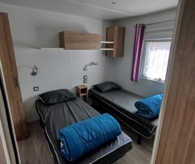 Intérieur de mobilhome avec deux lits simples dans le mobilhome MHVACANCES