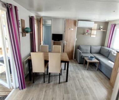 Intérieur avec coin salon canapé et table à manger dans le mobil-home MHVACANCES
