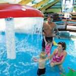 Piscine intérieure avec champignon d'eau et baigneurs au Domaine de Kerlann