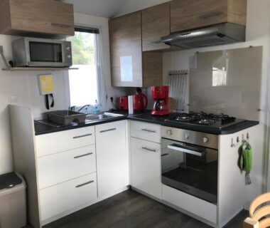 Cuisine équipée avec four plaque de cuisson et micro-ondes dans le mobil home du Domaine de Kerlann