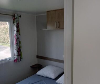 Chambre avec lit et fenêtre du mobil home 3 Chambres Camping La Pommeraie Trégunc