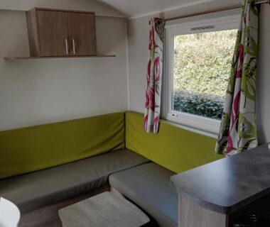 Intérieur coin salon avec banquette et fenêtre dans le mobil home 3 Chambres Camping La Pommeraie Trégunc