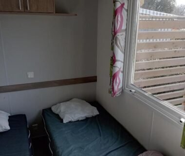 Chambre avec deux lits simples et fenêtre dans le mobil home MOBIL HOME 3 Chambres Camping La Pommeraie Trégunc