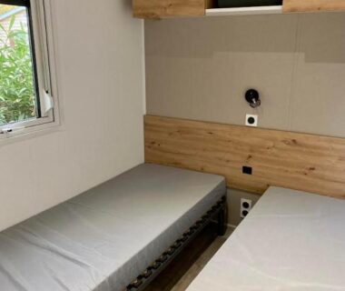 Chambre avec deux lits simples et fenêtre du MOBIL-HOME 3CH 34 m2 à SAINT-CYPRIEN