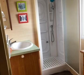 Salle d'eau avec cabine de douche et lavabo dans le mobil home 4 personnes entre rivière et mer