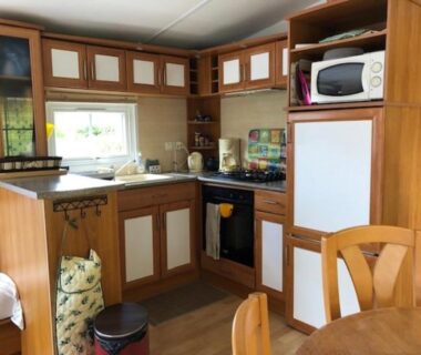 Cuisine équipée avec table et micro-ondes dans le mobil home 4 personnes entre rivière et mer