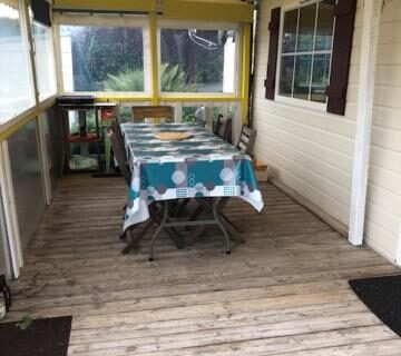 Terrasse couverte avec table et chaises du mobil home 4 personnes entre rivière et mer