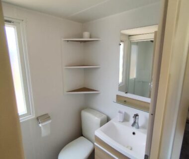Salle de bain avec lavabo miroir et WC dans le MOBIL HOME 40M2 ECRIN DE VERDURE