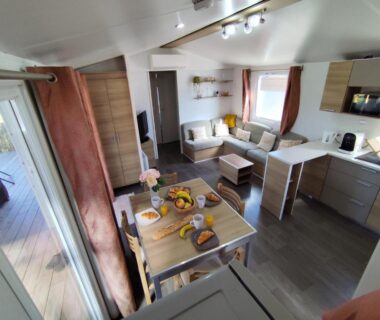 Intérieur avec coin repas salon et kitchenette du mobil home 40m2 Ecrin de Verdure