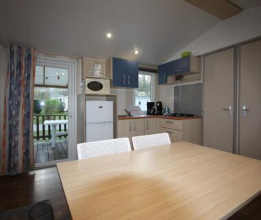 Intérieur kitchenette et table donnant sur la terrasse du MOBIL-HOME 6 PERSONNES CAMPING EUROLAC BORD LAC AUREILHAN