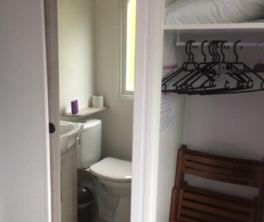 Toilettes avec fenêtre et placard à cintres dans le mobil home 6/8 places