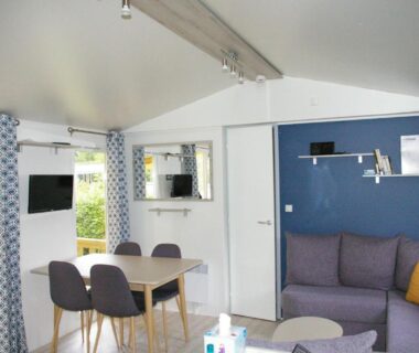 Salon intérieur avec canapé et coin repas dans le Mobil Home 6/8 places