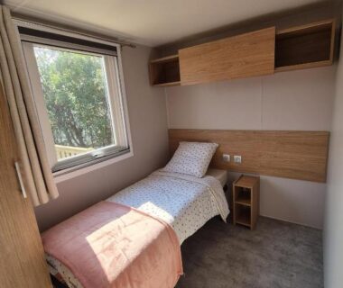 Chambre avec lit simple et fenêtre dans le Mobil Home Biscarosse Lac