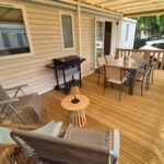 Terrasse en bois avec salon et barbecue du Mobil Home Biscarosse Lac
