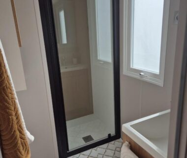 Salle de bain avec douche vitrée et lavabo dans le mobil home Biscarosse Lac