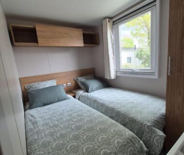 Chambre avec deux lits et fenêtre dans le Mobil Home Biscarosse Lac