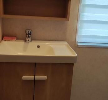 Salle de bain avec lavabo et miroir dans le Mobil Home Camping 3***