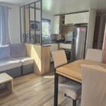 Séjour avec canapé coin repas kitchenette dans le mobil home Les Sables du Midi 3 chambres