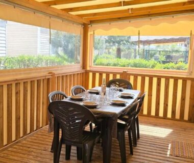 Terrasse couverte avec table et chaises dans le mobil home Camping Les Sables du Midi 3 chambres