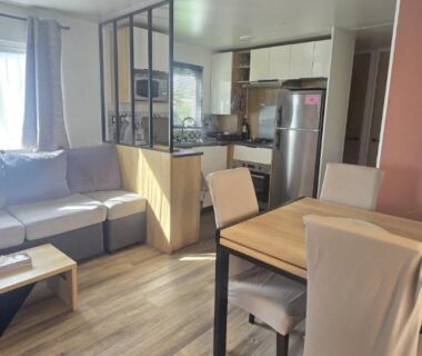 Séjour avec canapé coin repas kitchenette dans le mobil home Les Sables du Midi 3 chambres