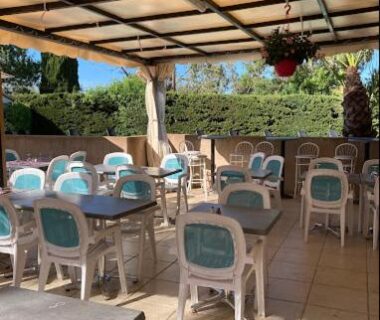 Terrasse couverte avec tables et chaises au Mobil Home Glamping Confort
