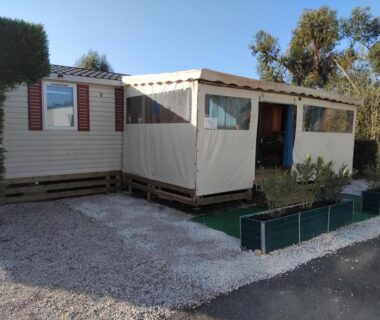 Allée gravillonnée et terrasse couverte du mobil home Glamping Confort
